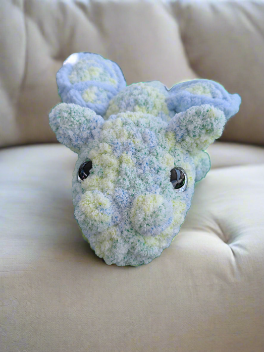 Plush toy dinosaur head on a beige couch