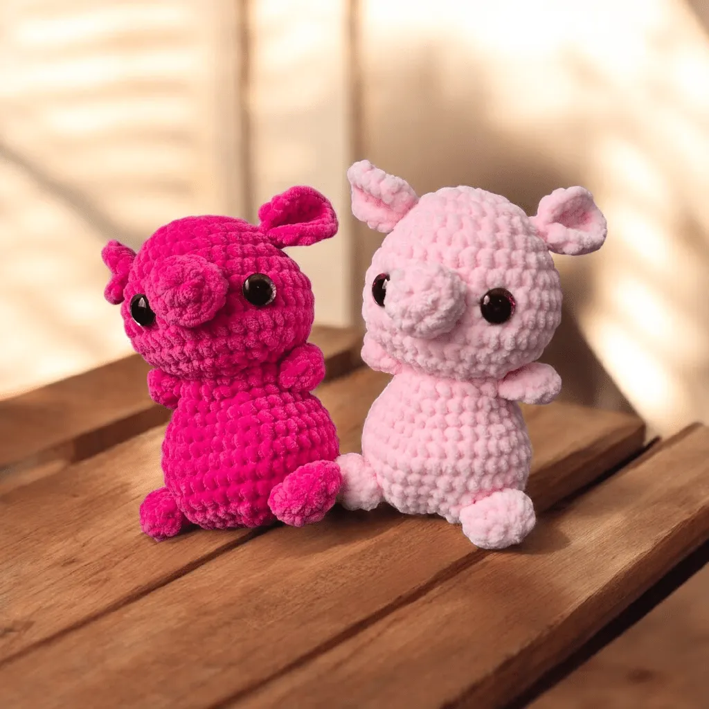 Two pink crocheted pigs